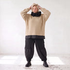 Beiger Strickpullover mit Rollkragen und seitlichen Schlitzen vorne kurz hinten lang